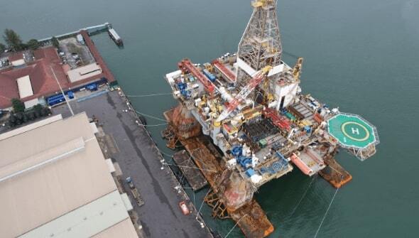 An offshore oil rig docked at a Malaysian port, showcasing efficient logistics coordination and streamlined operations.