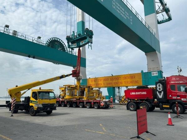 Heavy machinery and trucks performing logistics operations at a port, showcasing the transportation and handling of large industrial equipment.